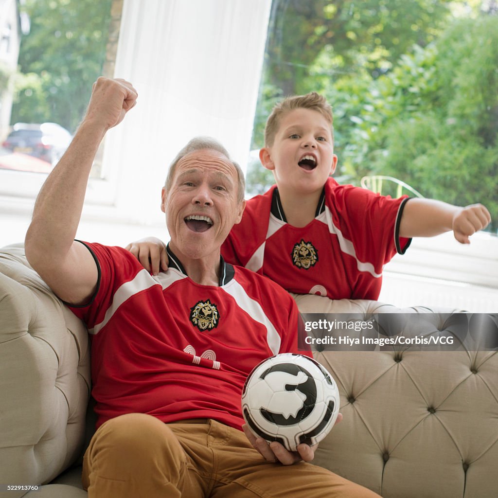 Grandfather and grandson (10-12 years) watching sports event