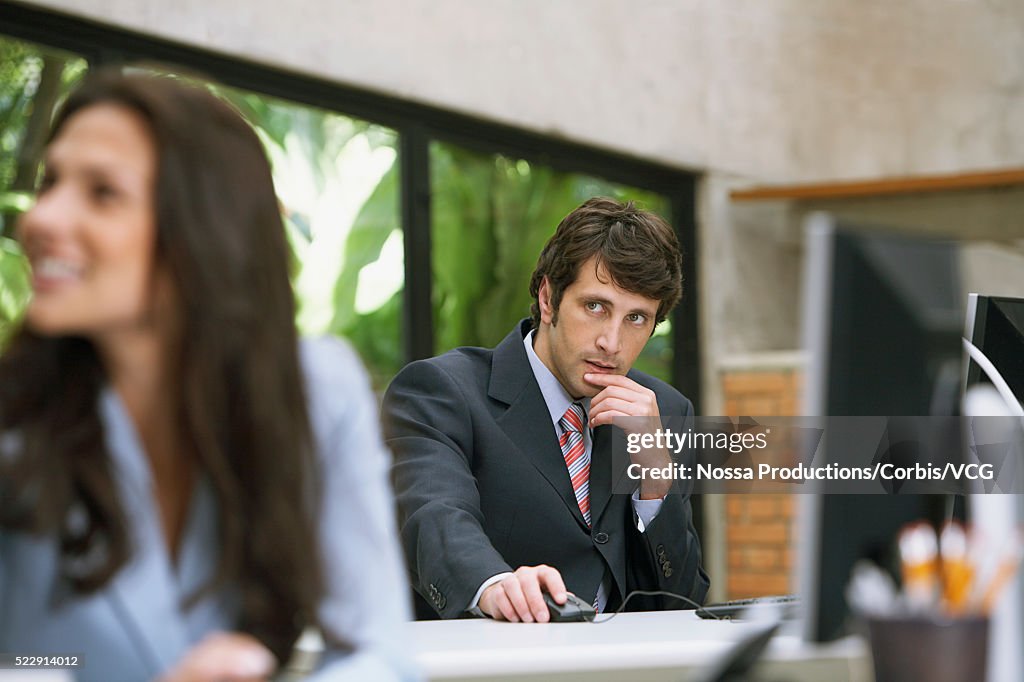 Suspicious businessman sitting at his desk