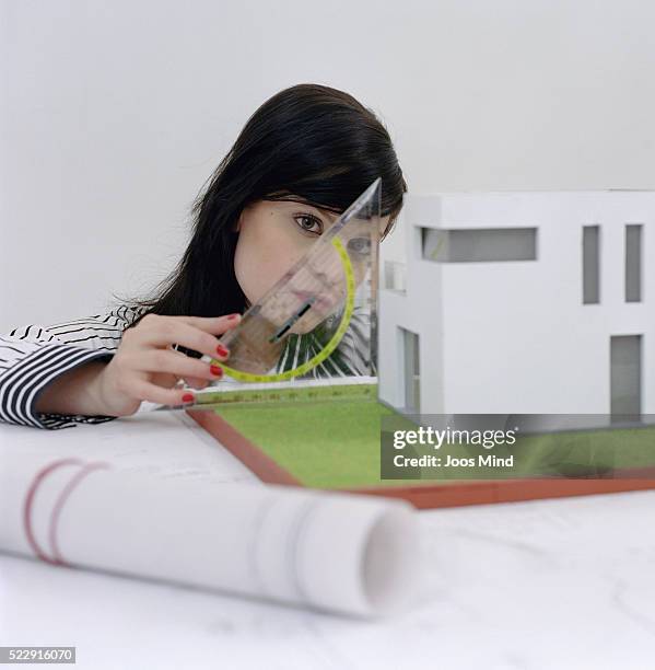 young woman measuring architectural model - protractor stock pictures, royalty-free photos & images