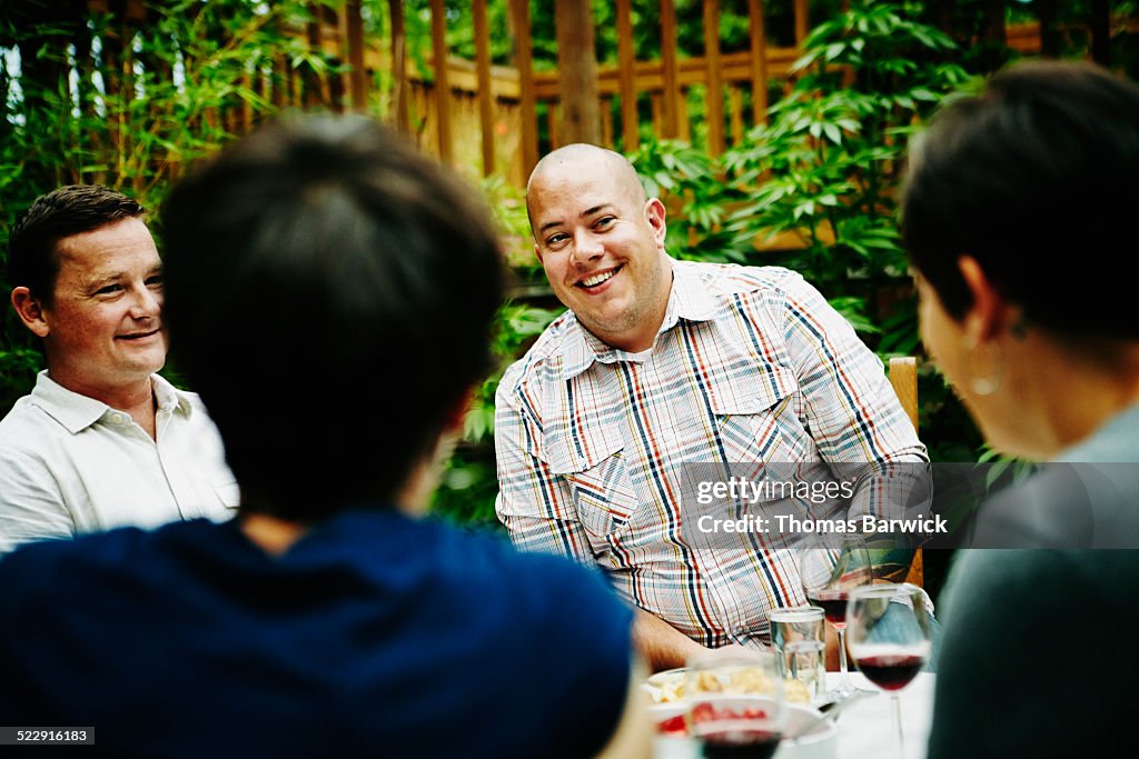 Man having dessert with friends in backyard