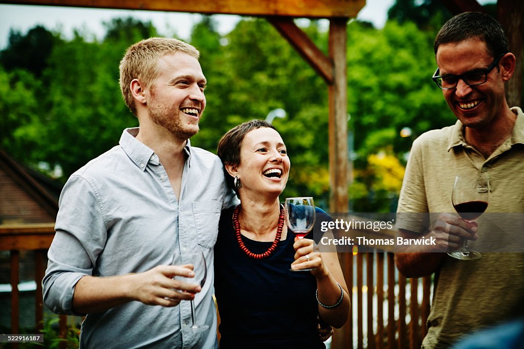 Couple drinking wine with friends on deck