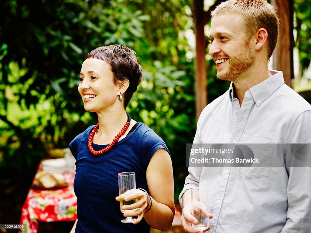 Laughing couple having drinks with friends