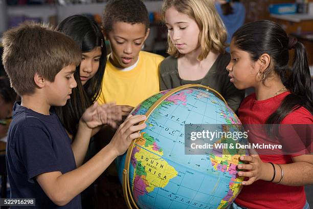 third grade students looking at globe - geografía física fotografías e imágenes de stock