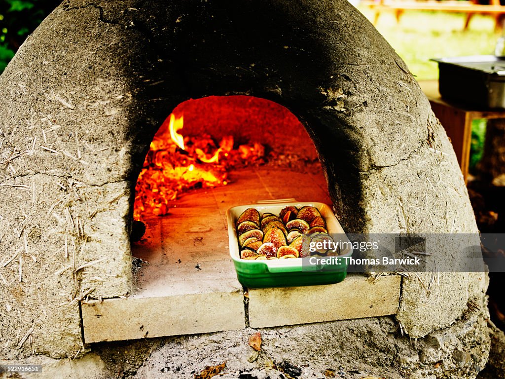 Figs warming in opening of outdoor brick oven