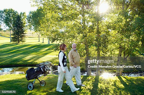 golfers on beautiful woodland golf course - golftasche ziehen stock-fotos und bilder