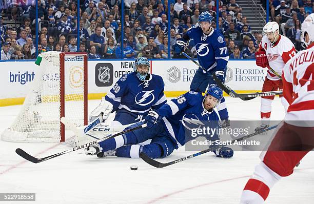 Braydon Coburn of the Tampa Bay Lightning slides to make a save in front of goalie Ben Bishop and Victor Hedman against the Detroit Red Wings during...
