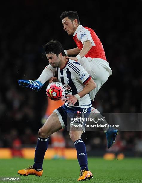 Mesut Ozil of Arsenal challenges Claudio Yacob of WBA during the Barclays Premier League match between Arsenal and West Bromwich Albion at Emirates...