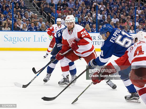 Valtteri Filppula of the Tampa Bay Lightning skates against Mike Green and Luke Glendening of the Detroit Red Wings during the third period of Game...