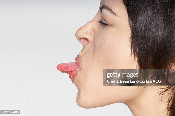 woman sticking out tongue - protruding ストックフォトと画像