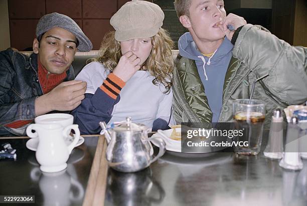 friends sharing french fries - girl eating french fries stock pictures, royalty-free photos & images