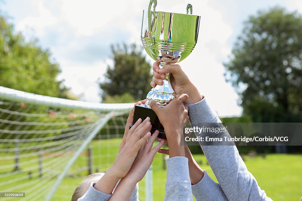 School soccer team holding trophy