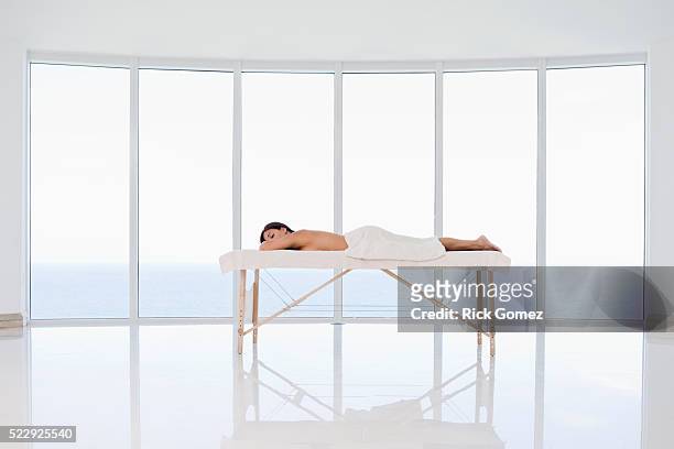 woman lying on a massage table - banc de massage photos et images de collection
