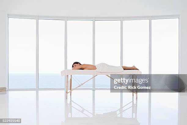 woman lying on a massage table - massage table imagens e fotografias de stock