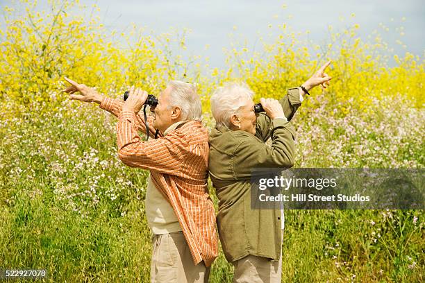 bird watchers pointing in two directions - bird watching stock pictures, royalty-free photos & images