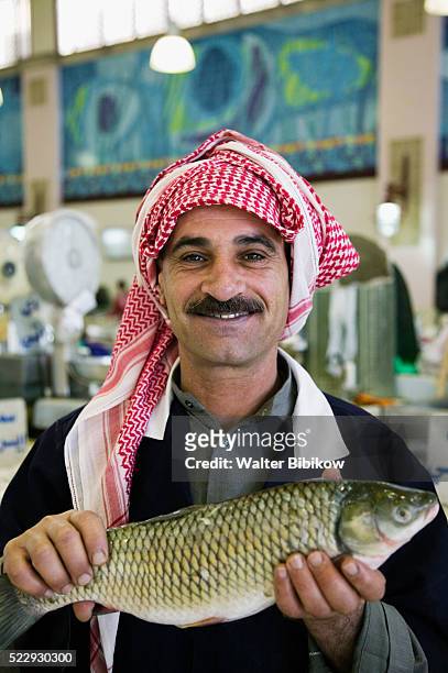 fish monger at kuwait city fish market - kuwaiti stock pictures, royalty-free photos & images