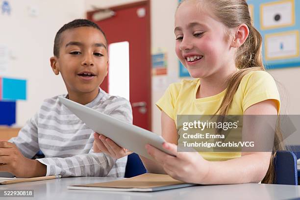 elementary students (6-7) using tablet pcs in classroom - children only stock pictures, royalty-free photos & images