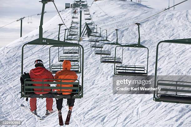 skiers on a chair lift - sessellift stock-fotos und bilder