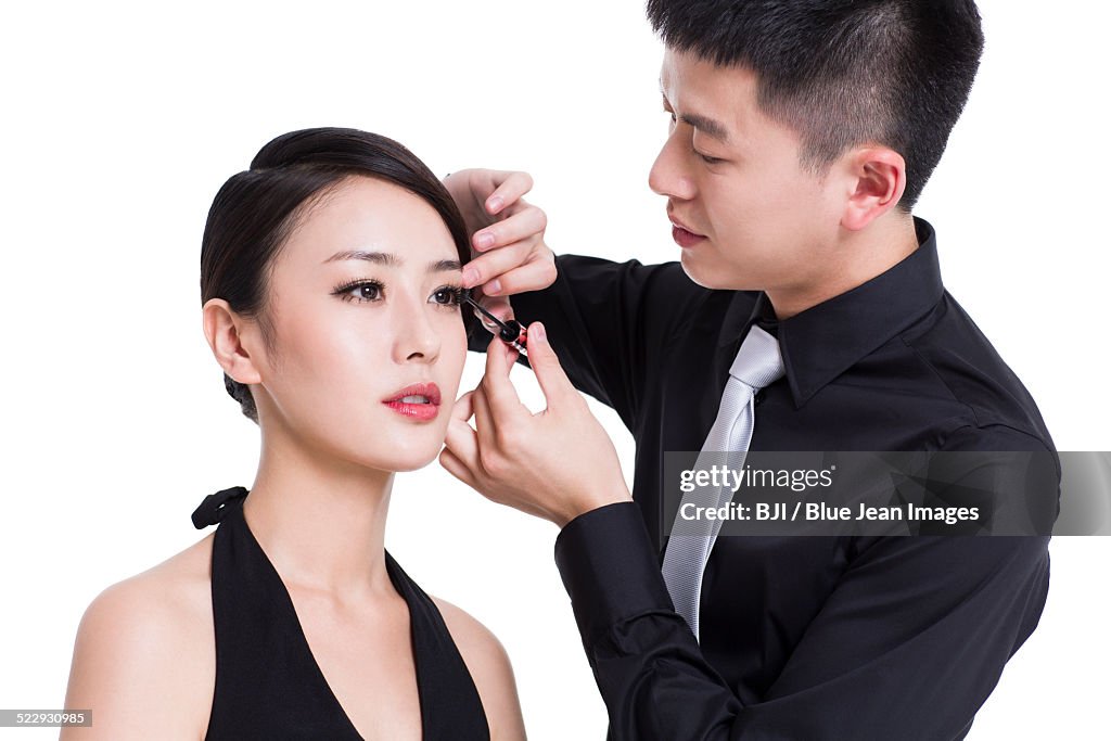 Makeup artist applying make-up to young woman