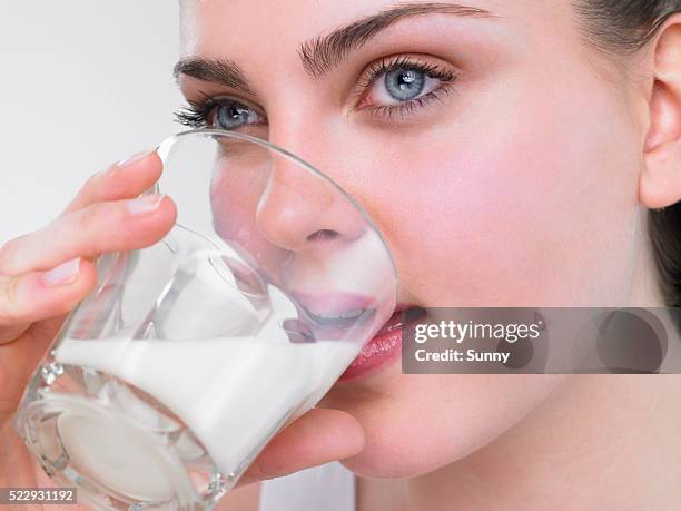 woman drinking a glass of milk - woman drinking milk stock pictures, royalty-free photos & images