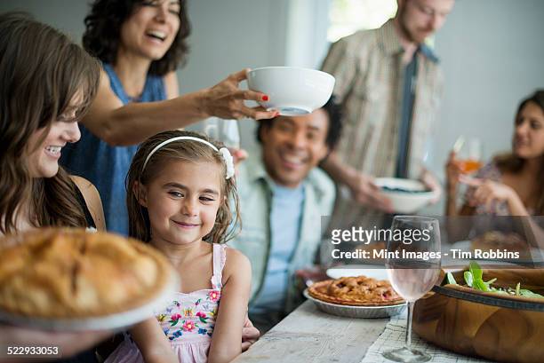 a family gathering for a meal. adults and children around a table. - party pies foto e immagini stock