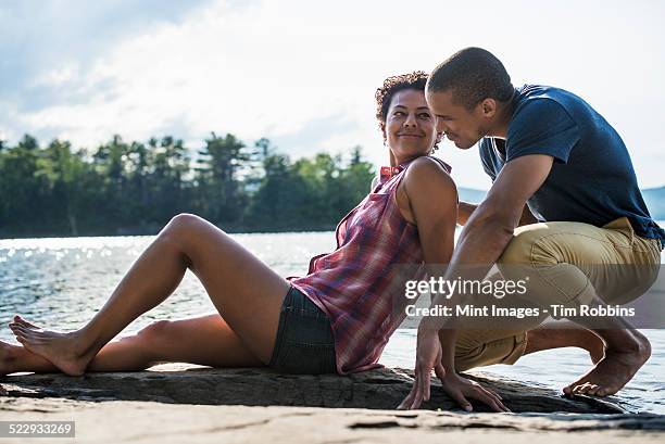 a couple close together by a lake in summer. - woodstock new york stockfoto's en -beelden