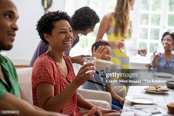 a family gathering, men, women and children around a dining table sharing a meal. - woodstock new york stock pictures, royalty-free photos & images