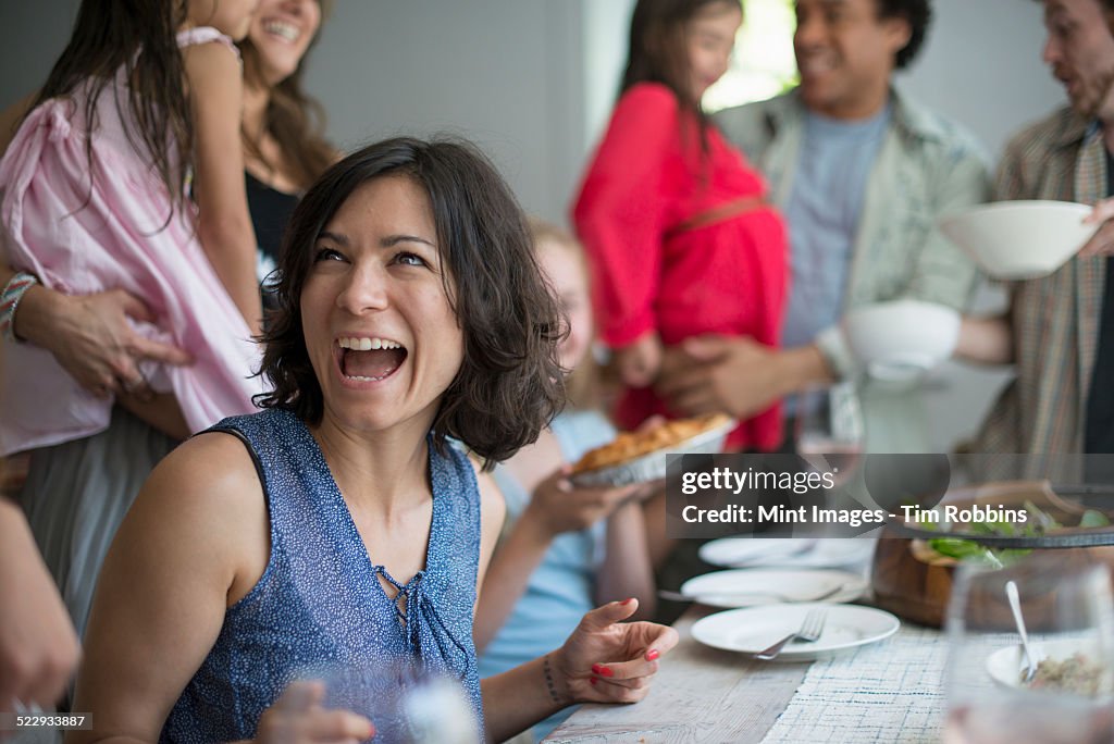 A family gathering for a meal. Adults and children around a table.