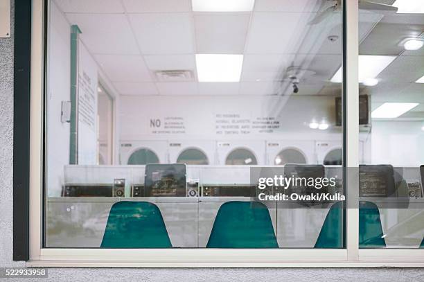 laundromat through window - waschsalon stock-fotos und bilder