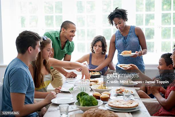 a family gathering for a meal. adults and children around a table. - mesa de jantar - fotografias e filmes do acervo