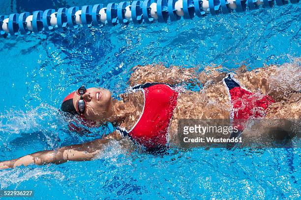 woman with red bikini swimming in pool - backstroke ストックフォトと画像
