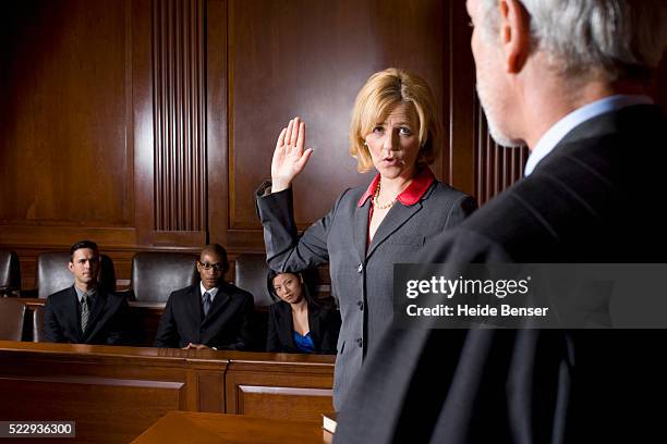 witness giving oath during trial - déposition photos et images de collection