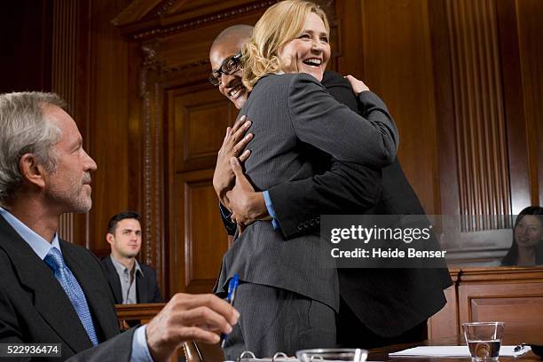 lawyer and defendant celebrating victory in trial - courtroom defendant stock pictures, royalty-free photos & images