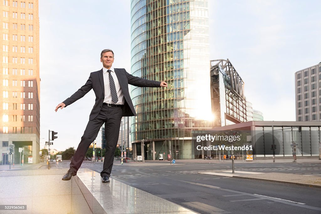 Germany, Berlin, Businessman balancing on balustrade