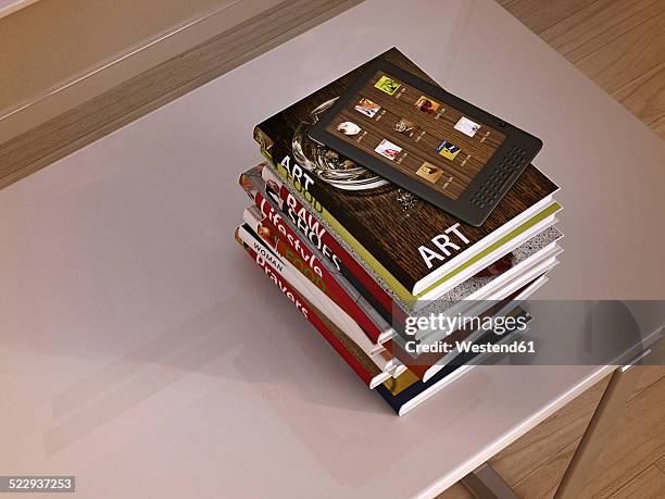 e-reader and stack of books lying on a table, 3d rendering - book stack top view stock illustrations