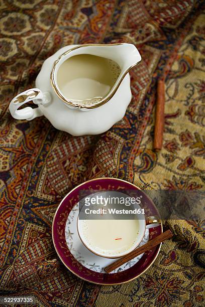 milk pitcher and demitasse cup of soy rice milk spiced with saffron and cinnamon on cloth - milk pitcher ストックフォトと画像