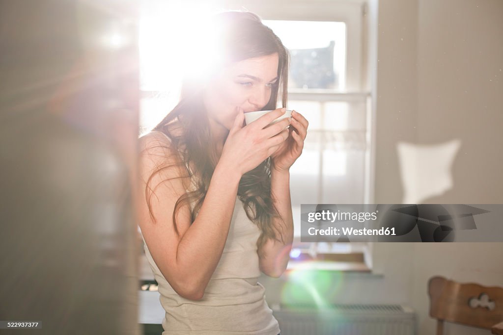 Portrait of young woman drinking tea in the morning