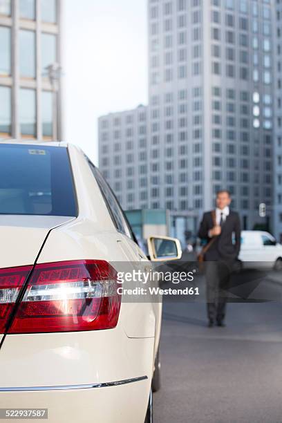 germany, berlin, businessman taking a taxi - rear light car stock-fotos und bilder
