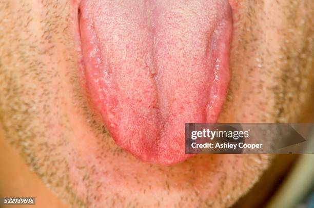 unshaven man sticking out tongue - mettere fuori la lingua foto e immagini stock