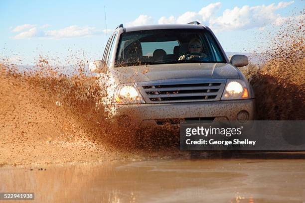 crossing a flooded stream - car splashing stock pictures, royalty-free photos & images
