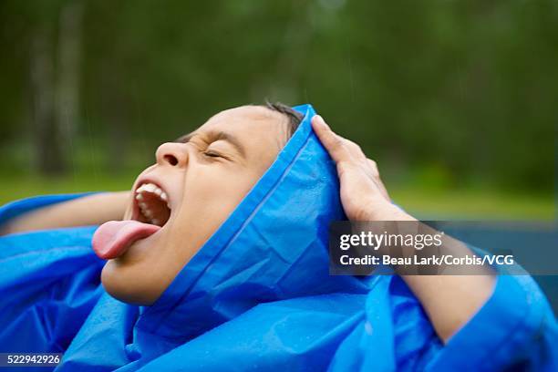 girl catching raindrops - caught in rain stock pictures, royalty-free photos & images