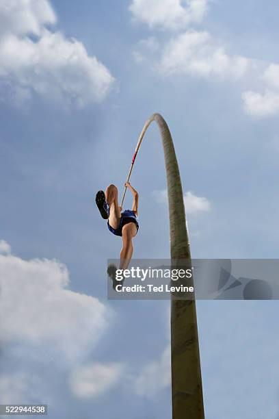 pole vaulter in midair - stabhochsprung stock-fotos und bilder