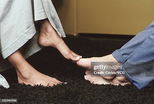 couple playing footsie - playing footsie stock-fotos und bilder