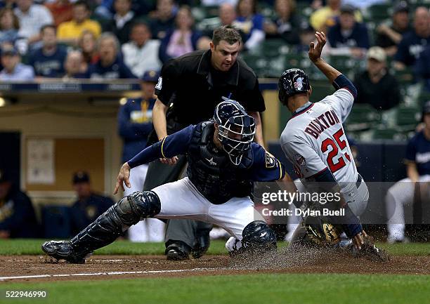 Byron Buxton of the Minnesota Twins slides safely into home past Jonathan Lucroy of the Milwaukee Brewers in the eighth inning at Miller Park on...