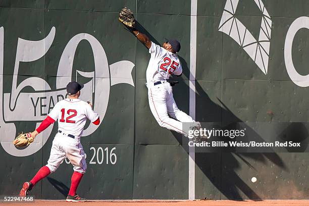 Jackie Bradley Jr. #25 of the Boston Red Sox attempts to catch a fly ball off the Green Monster as Brock Holt looks on during the eighth inning of a...