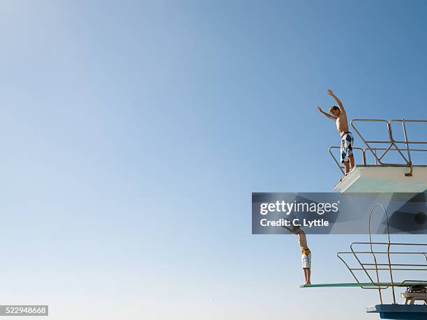 two teenage boys on diving boards - diving board stock pictures, royalty-free photos & images