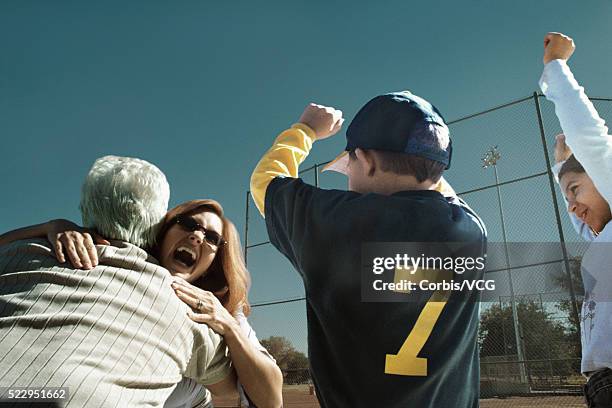 family celebrating victory at baseball game - baseball mom fotografías e imágenes de stock