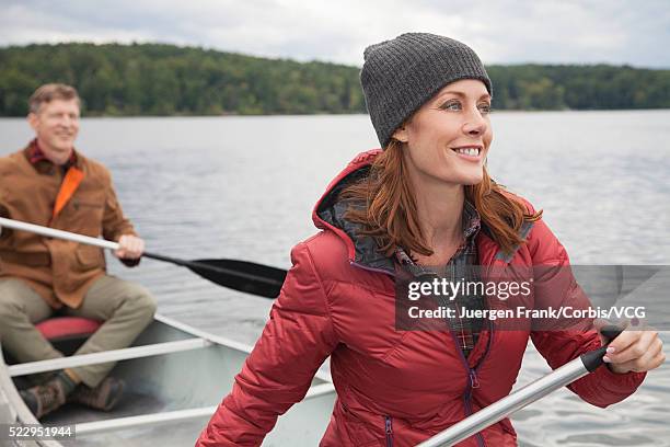 couple puddling in canoe on lake - puddling stockfoto's en -beelden