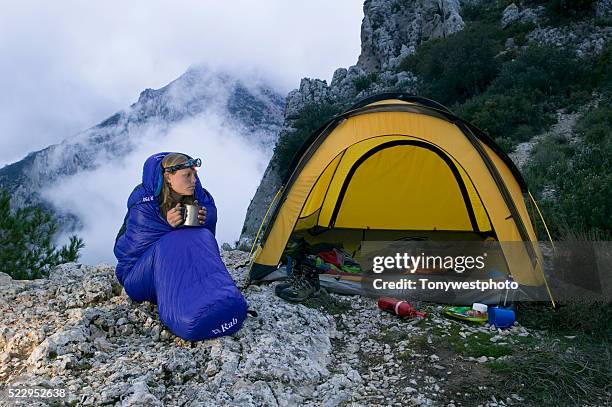 woman in sleeping bag next to tent - sleeping bag stock pictures, royalty-free photos & images