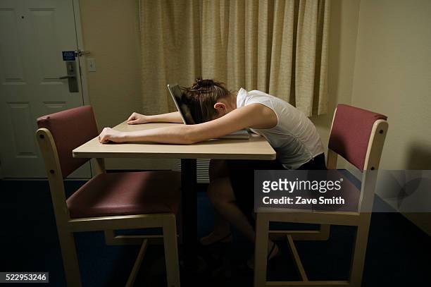 young woman asleep on laptop - frustración fotografías e imágenes de stock