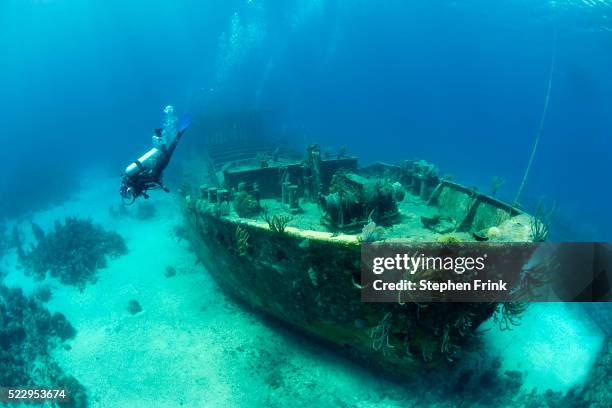 scuba diver exploring a large shipwreck - shipwreck stock pictures, royalty-free photos & images